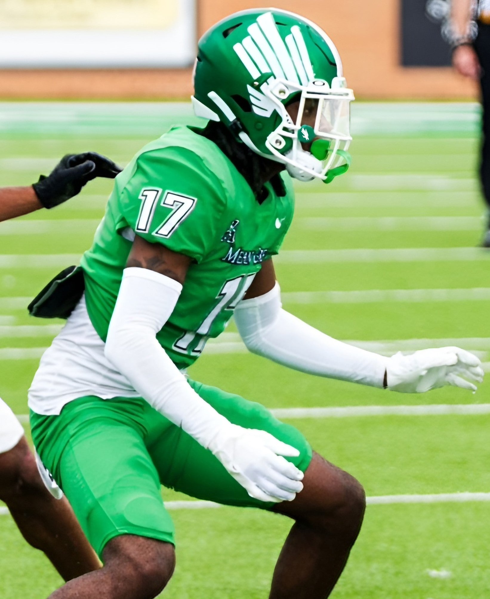 University of North Texas football player, number 17 wearing all green uniform, pants and helmet with white facemask and clear visor with green visor clips and white UNT eagle logo.