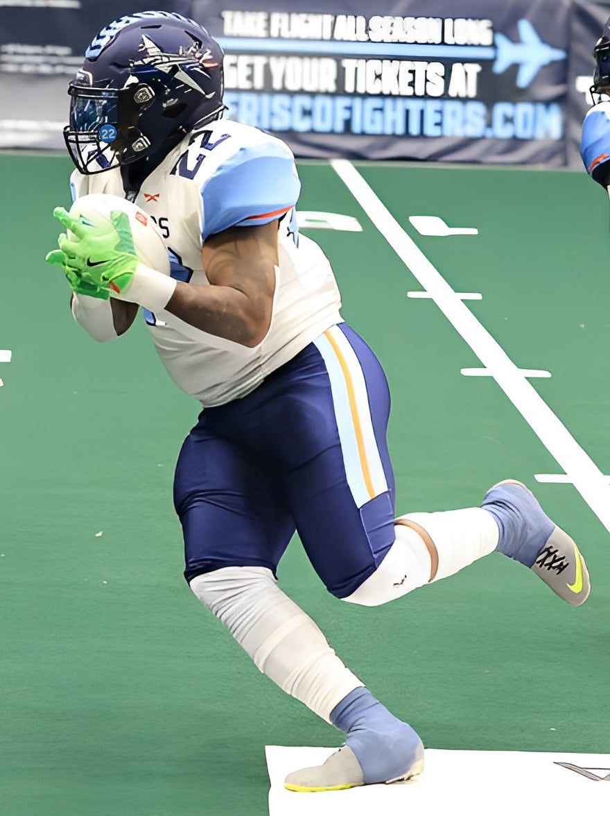 Football player in full uniform with white jersey navy pants and helmet. Light blue shaded visor and light blue visor clips with number 22 in white.